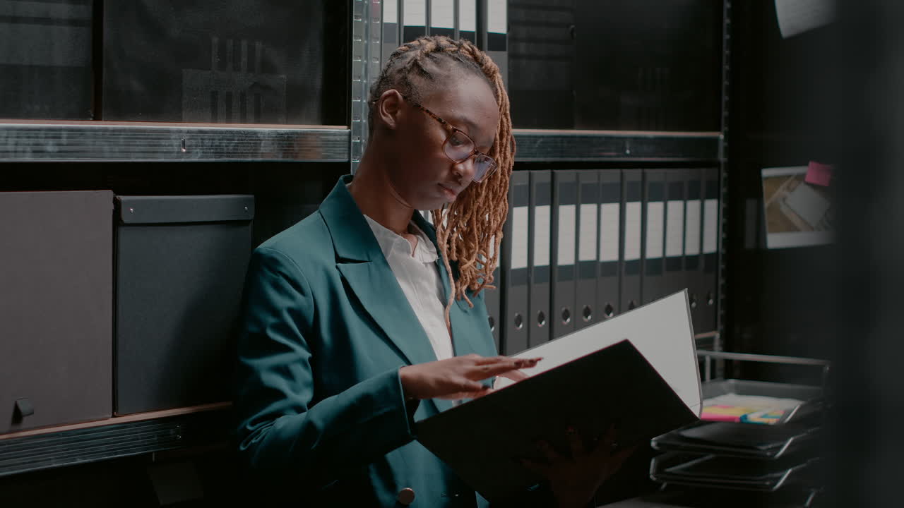 Businesswoman looking at documents in filing cabinet