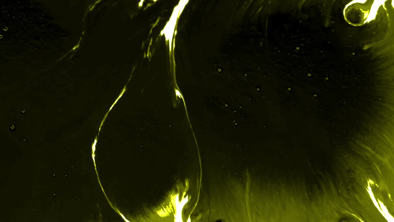 Splashes and spots of yellow ink spreading on white background