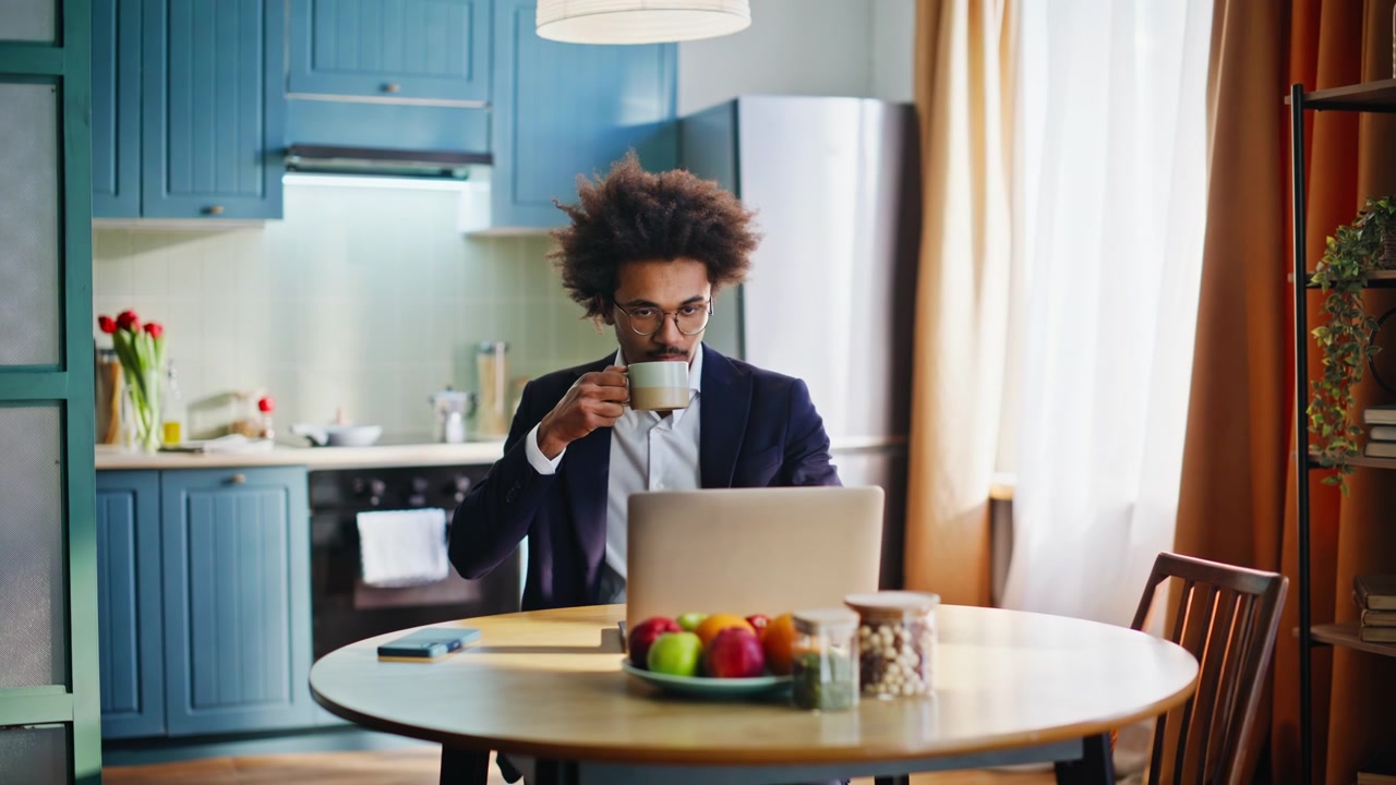 Uomo d'affari multietnico che finisce il caffè mattutino nella cucina di casa. Si affretta al lavoro