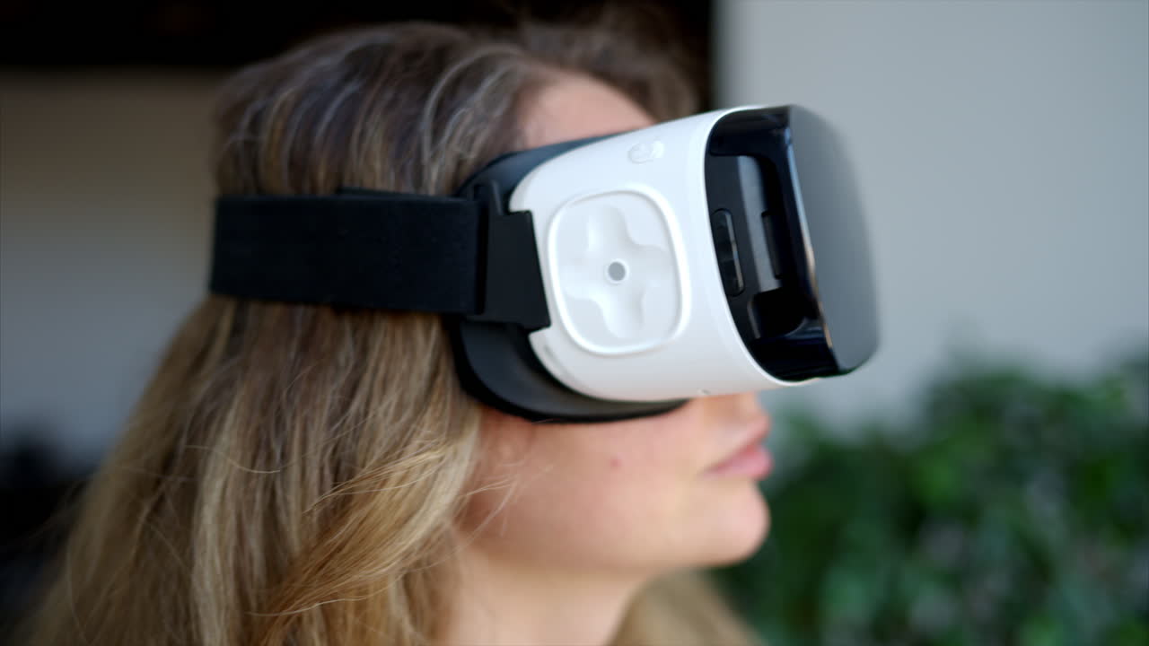 Woman with long hair wearing black VR virtual reality headeset and playing