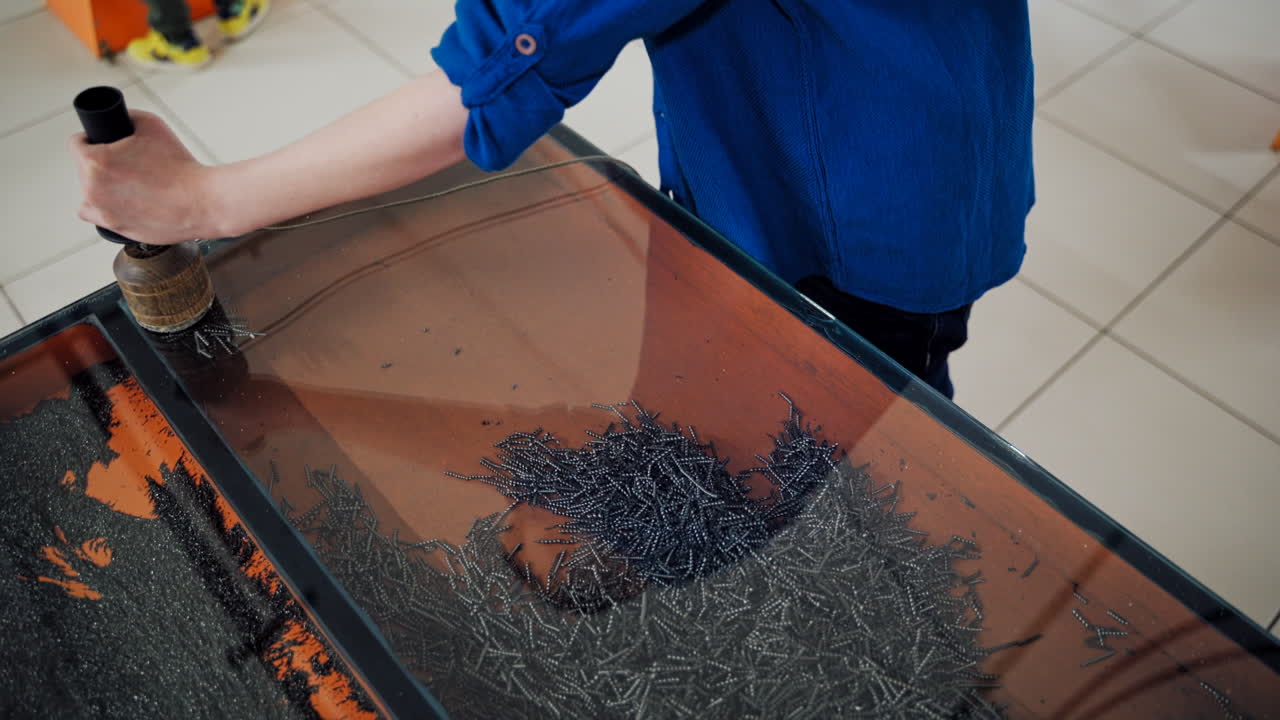 Boy conducts research experience. Iron shavings and magnet. Science museum