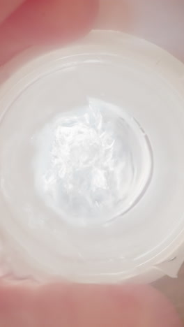 preschooler takes bottle with measuring divisions and drinks water through white silicone nipple. child saturates with clear liquid and puts bottle macro low angle shot