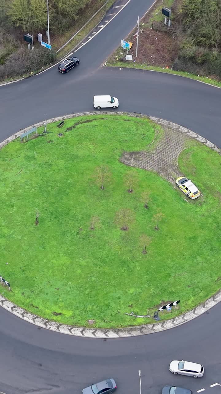 Vertical Drone rise at Waltham Abbey roundabout with traffic and Highways Agency Car
