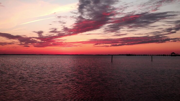 Beautiful and dramatic unedited red sunset sky over a body of calm water with gentle breeze