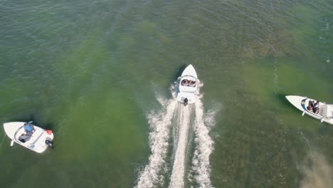 4k footage from drone flying over a boat speeding in the ocean