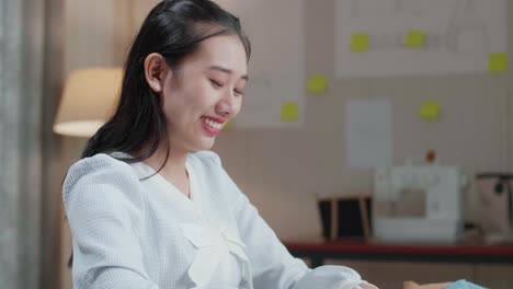 아시아 여성 디자이너의 클로즈업 레이아웃을 보십시오. 사무실에서 노트북으로 작업하는 동안 을 고 카메라에 미소를 지으십시오.