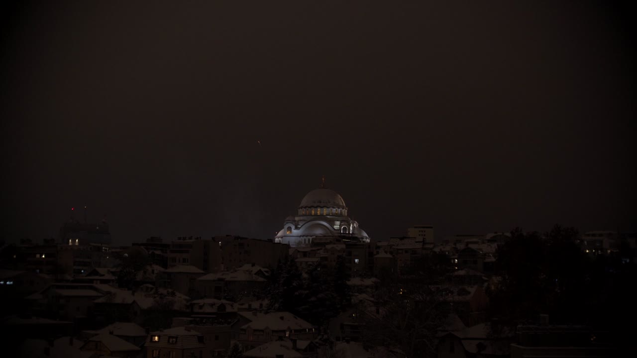 tiro estático en cámara lenta de un cohete de fuegos artificiales lanzado cerca de un gran templo cristiano ortodoxo en belgrado en la víspera de navidad