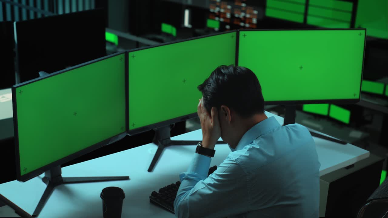 사무실 에서 여러 개의 컴퓨터 모니터 를 모방 하여 작업 하는 동안 두통 을 겪는 아시아인 의 측면 시각