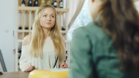 An-Attractive-Woman-Buys-Food-In-A-Small-Store-The-View-From-The-Side-Of-The-Counter