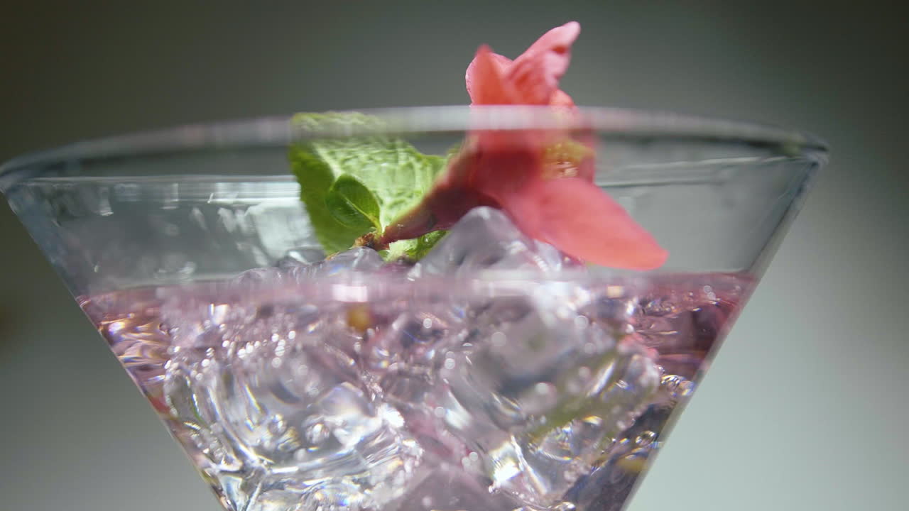 decoración de cócteles con una flor roja, cubos de hielo están rodeados de soda.