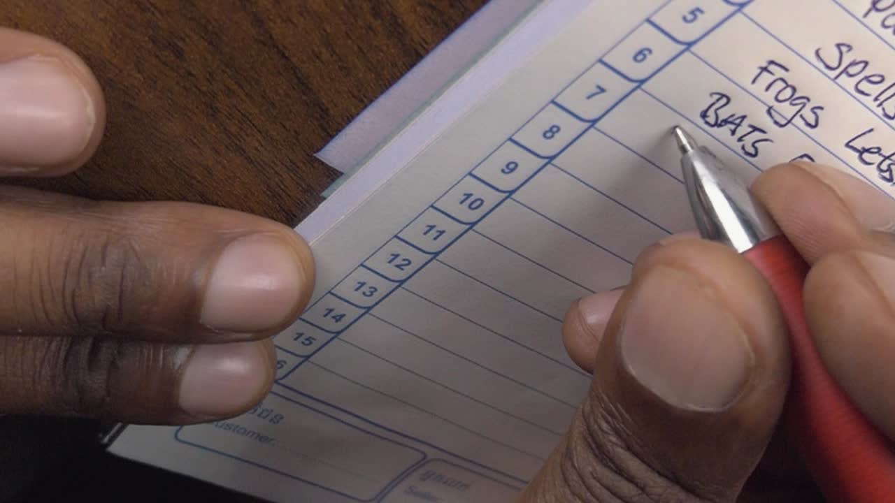 Man Writing Down Item in an Invoice