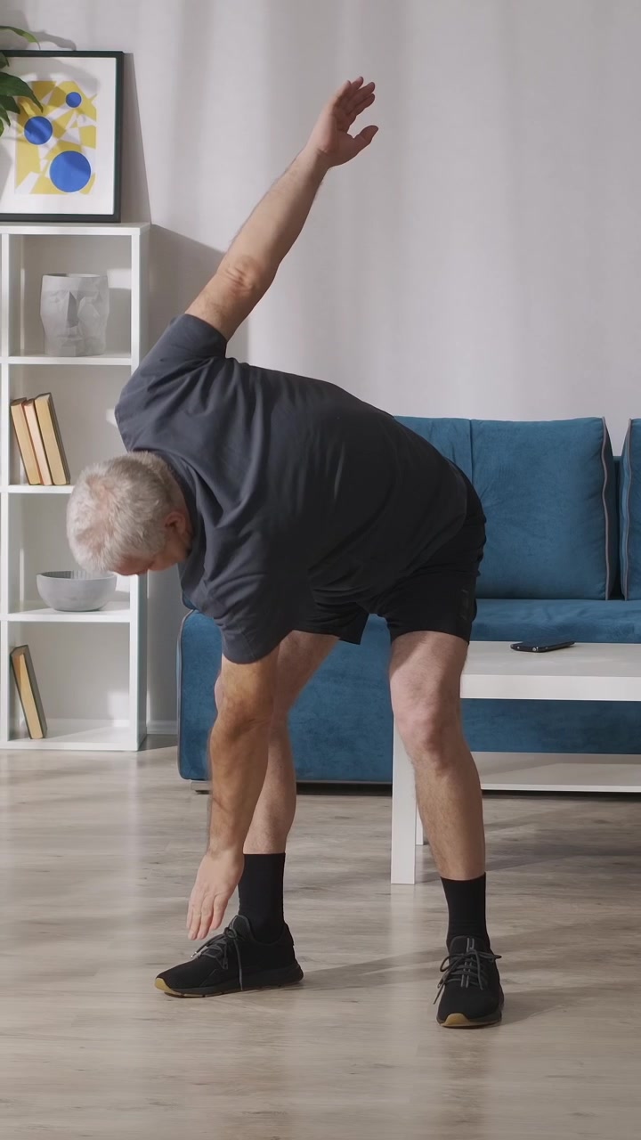 Senior Man Stretching and Exercising in Living Room