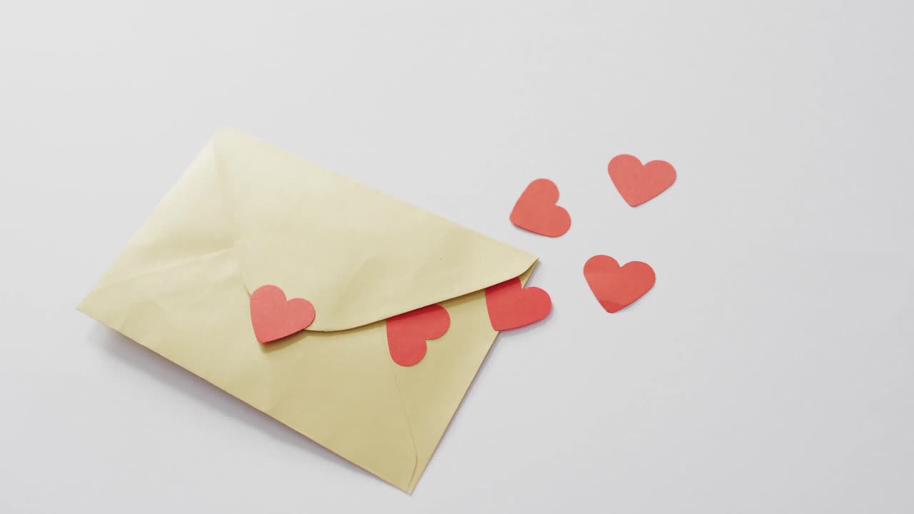 Paper hearts and envelope on pink background at valentine's day