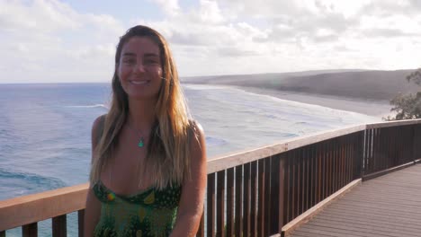 Chica-Guapa-Posando-En-North-Gorge-Walk-Con-Una-Playa-Idílica-En-El-Fondo---Lugar-Turístico-Cerca-De-South-Gorge-Beach-En-Point-Lookout,-Queensland,-Australia