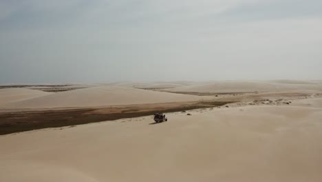 antena: un camión con kitesurfistas viajando a través de las dunas de lencois maranhenses en brasil, durante la estación seca