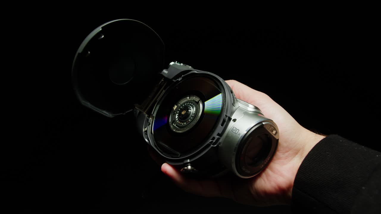 Old vintage video camera close-up. Popular retro camcorder shooting. Opening video-camera on black background