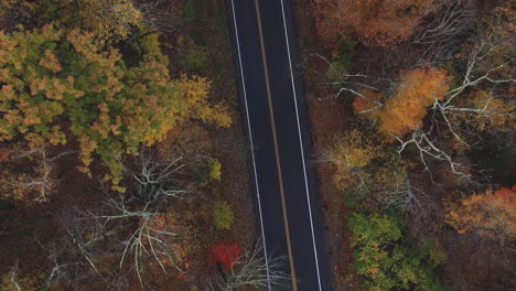 Drohne,-Die-Im-Herbst-über-Die-Zweispurige-Autobahn-In-Neuengland-Fliegt,-Mit-Blättern,-Die-Ihre-Farben-ändern-4