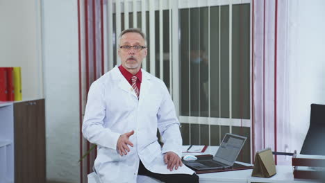 online conference doctor looking at the camera. frontal view of doctor talking to camera at clinic