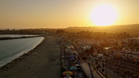 Santa-Cruz-California-Antena-V9-Cinemático-Sobrevuelo-Junto-Al-Mar-Playa-Paseo-Marítimo-Parque-De-Atracciones-A-Lo-Largo-De-La-Calle-Con-Un-Hermoso-Sol-Naranja-Brillante-Poniéndose-En-El-Cielo---Filmado-Con-Cine-Mavic-3---Mayo-De-2022