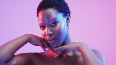 mujer afroamericana con cabello oscuro corto en luz azul y rosa con espacio de copia, cámara lenta