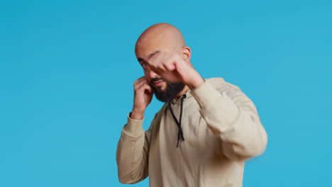 modelo masculino musulmán actuando agresivamente con los puños cerrados