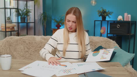 caucasian woman frustrated with bill errors at home on table holding documents feeling bankrupt