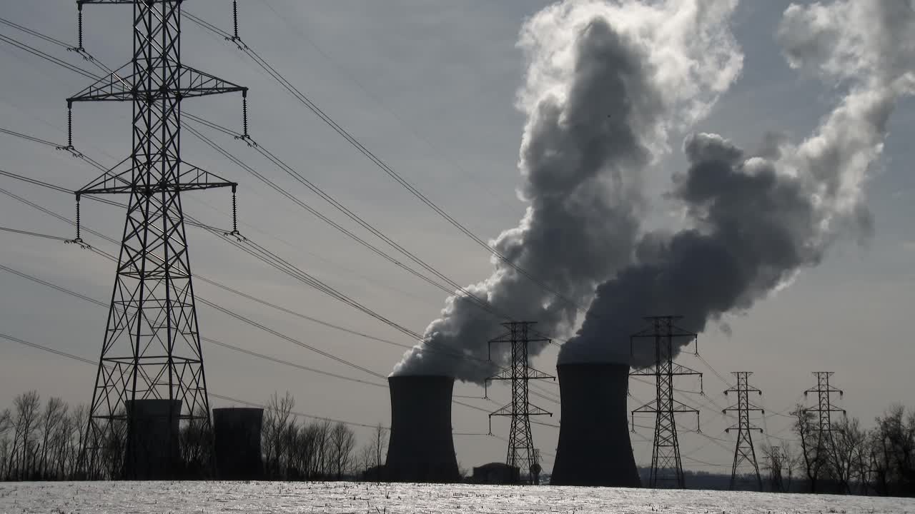 il fumo sale dalla centrale nucleare a tre miglia di isola in pennsylvania con linee elettriche in primo piano