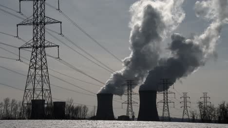 el humo se eleva desde la planta de energía nuclear en three mile island pensilvania con líneas eléctricas en primer plano