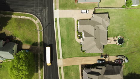 a school bus driving through a quiet suburban neighborhood in collierville, tennessee, aerial view