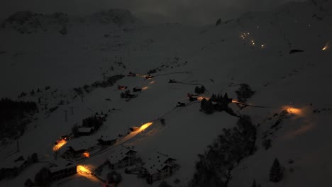 Toma-Aérea-De-Un-Automóvil-Conduciendo-Por-Una-Carretera-En-Las-Montañas-Nevadas-De-La-Ciudad-De-Arosa,-Suiza