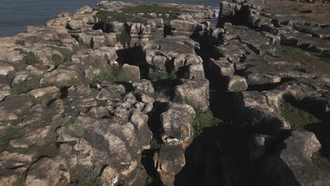 aerial drone top down view of eroded coast near peniche in portugal, reefs and atlantic ocean