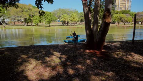 people kayaking on a sunny day in a park lake