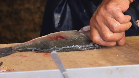 preparing fish at a market