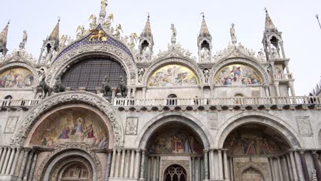 frontal pan across ornate historic saint marks basilica on foggy grey day