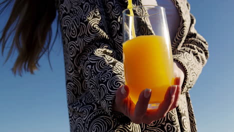 pouring orange juice into a glass outdoors