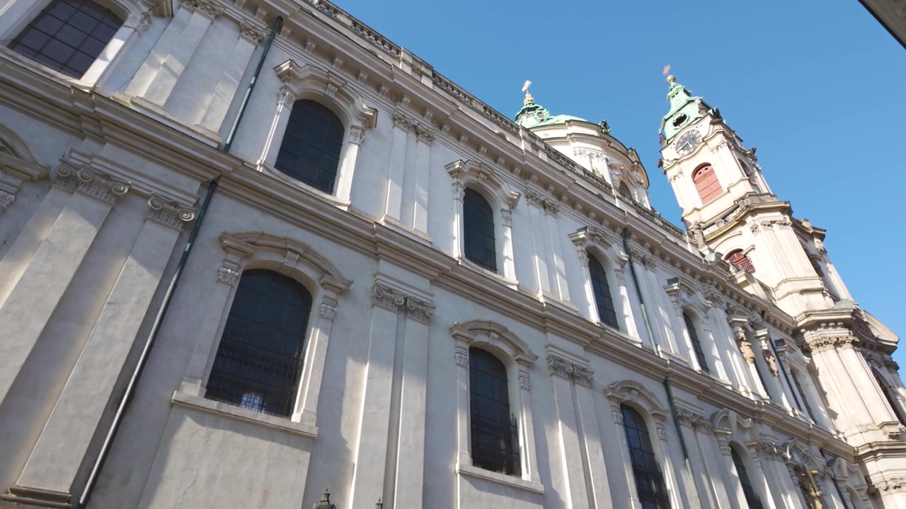 Panorámica de la Iglesia de San Nicolás en la Plaza de Malá Strana en Praga, mostrando su diseño barroco e importancia histórica