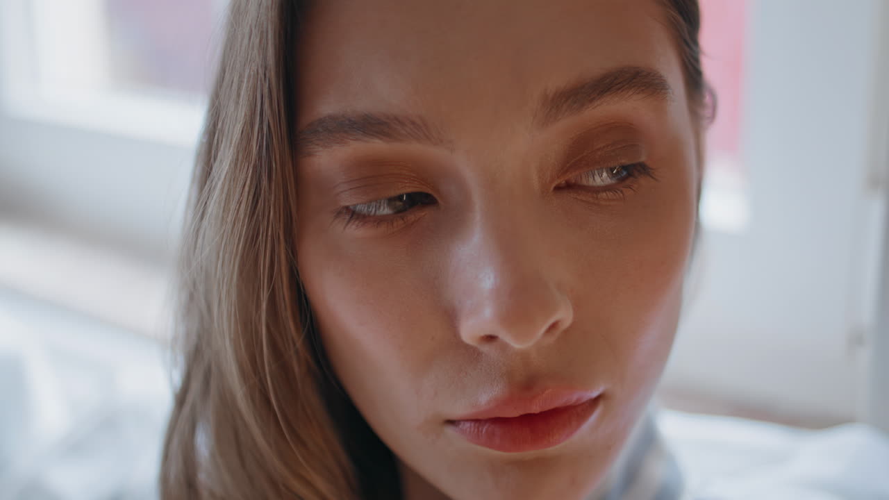 Closeup peaceful woman face looking away in white home interior. Portrait girl
