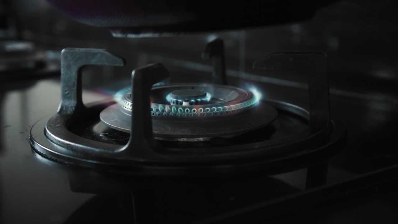 부에서 파란색과 빨간색으로 불타는 불꽃이 있는 검은색 가스 스토브의 비디오