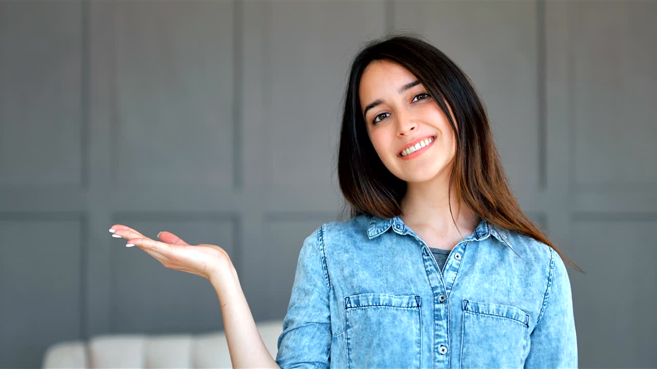 mujer feliz presentando con la mano abierta sosteniendo algo en blanco en el interior