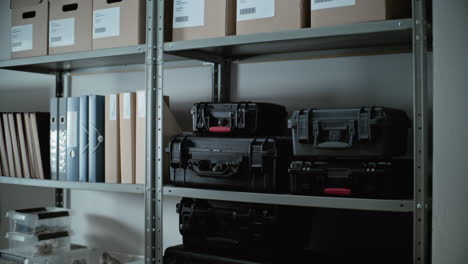 scientist organizing equipment cases and boxes in a storage room