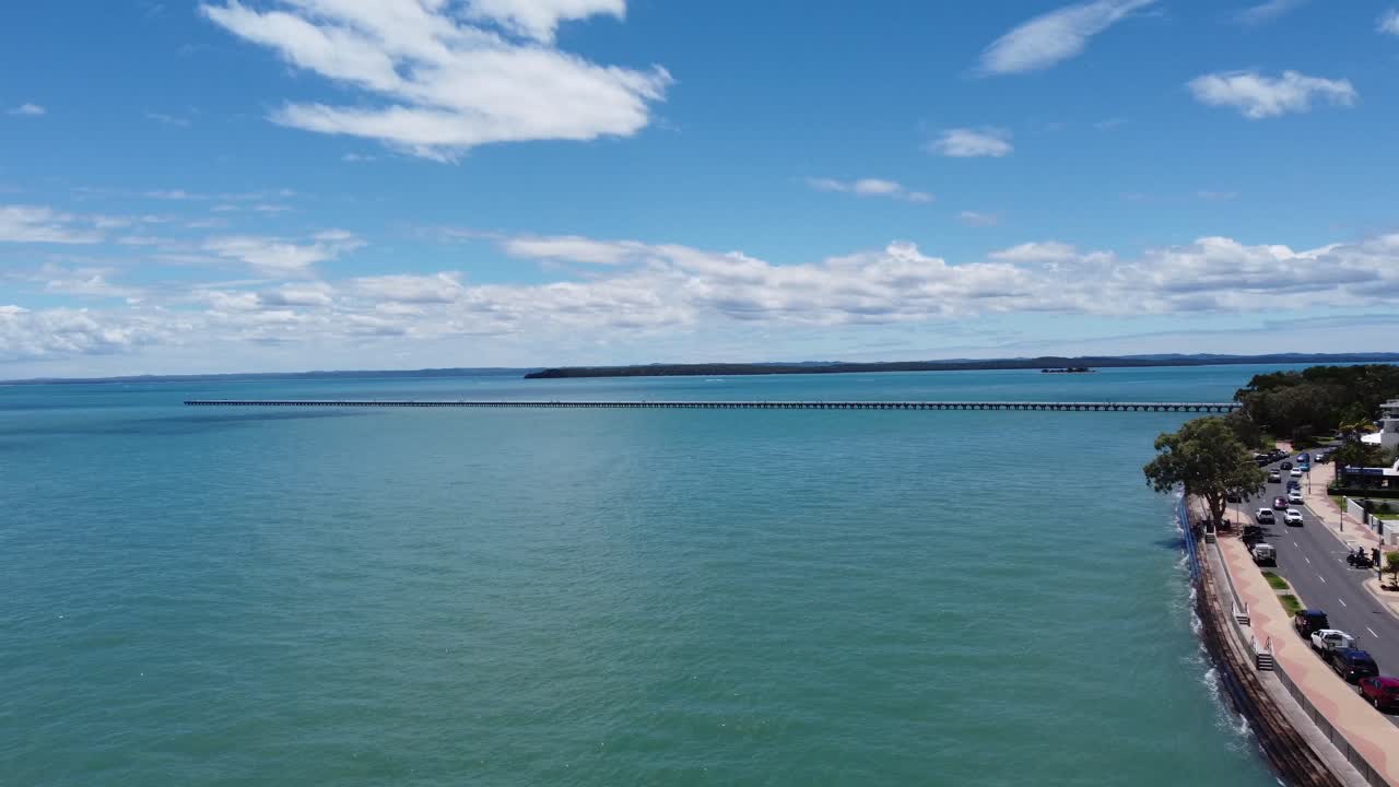 volando hacia el mar con un muelle muy largo en la distancia