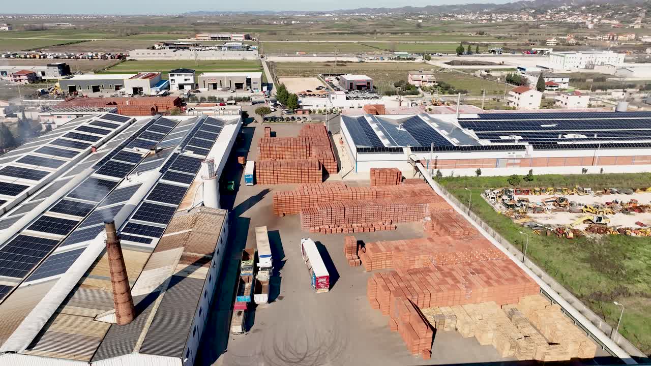 Aerial shot of brick factory with photovoltaic panels on rooftops