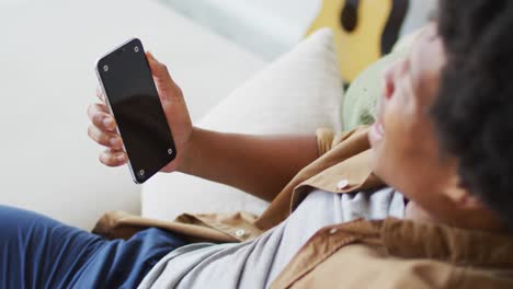 Happy-african-american-man-using-smartphone-at-home