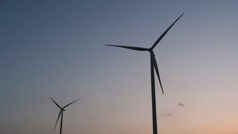 wind turbines silhouette against the blue-sky during sunset, clean alternative energy in thailand and mainland southeast asia