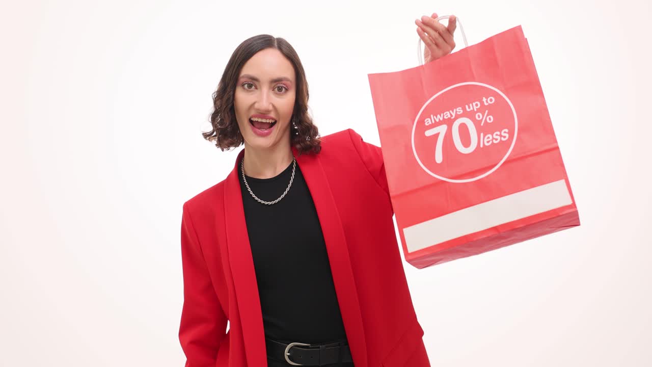 Donna mostra carta di credito e solleva una borsa per acquisti con percentuale di sconto.