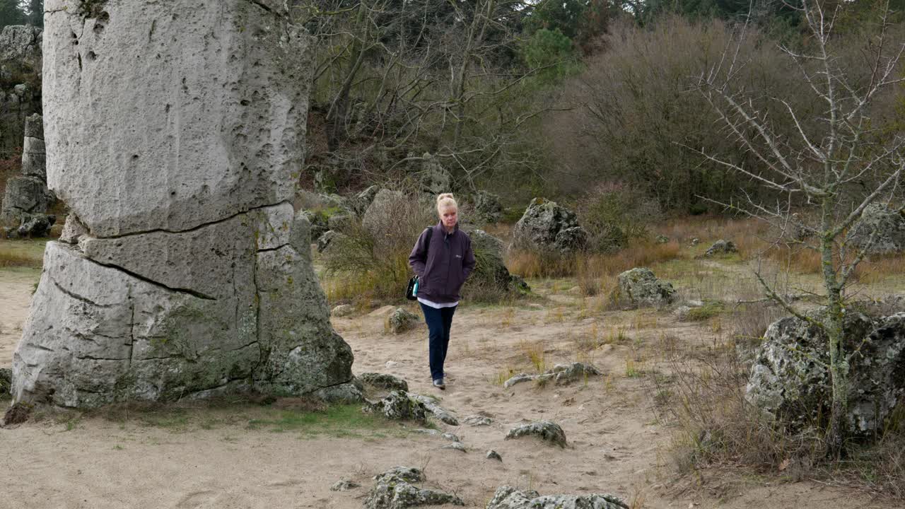 Donna solitaria cammina tra enormi e antiche formazioni rocciose Pobiti Kamani.