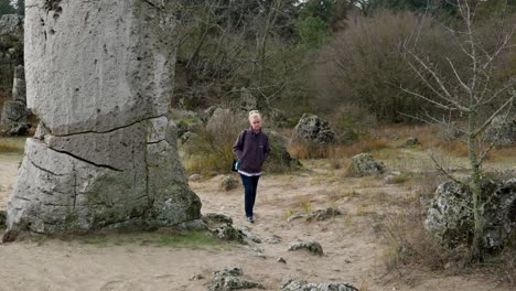 Solitary-woman-walks-among-huge-ancient-rock-formations-pobiti-kamani