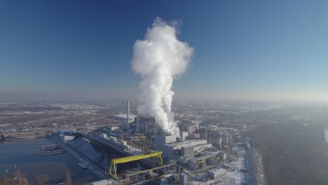 aerial approach to the coal-fired heating power station with thick white smoke coming from the chimney, environmental pollution concept