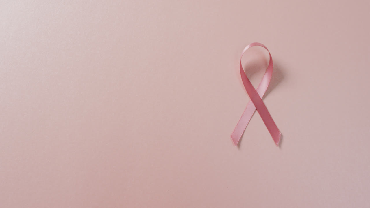 video de la cinta rosa del cáncer de mama en un fondo rosa pálido