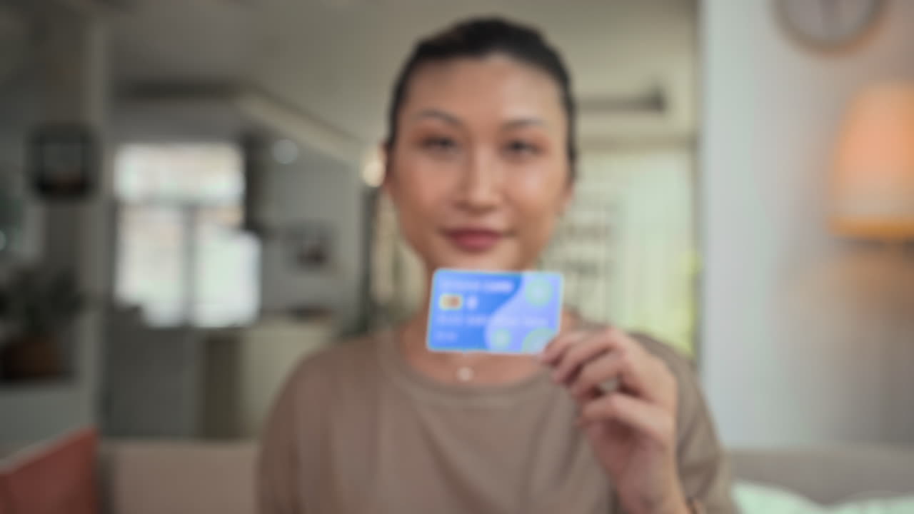 Woman Showing New Credit Card to Camera Indoors
